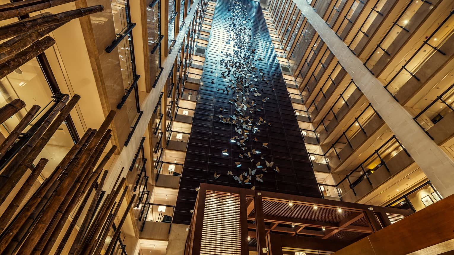 Looking up in 20-storey hotel atrium at 400 stainless-steel butterflies on column